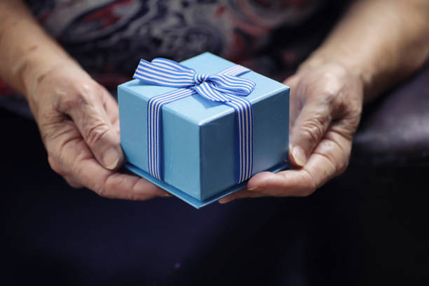 istock elder woman holding gift 1068828812