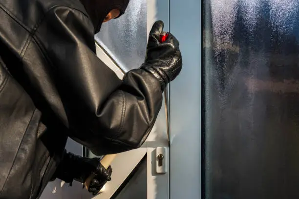 burglar opening front door of a house