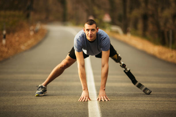 istock Young men with prosthetic legs stretching in the forrest 1068837828