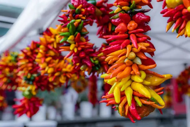 Assortment of colorful chili pepper ristras and wreath hanging at the Market in Seattle
