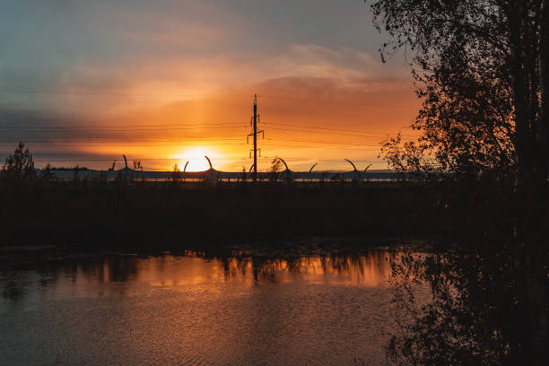 istock Highway and power lines on sunset background, view from the riverbank 1068844632