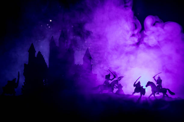 istock Medieval battle scene with cavalry and infantry. Silhouettes of figures as separate objects, fight between warriors on dark toned foggy background with medieval castle. Night scene. Selective focus 1068854124