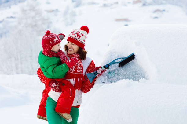 istock Mother and child brushing off car in winter. 1068856684