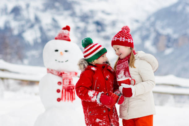 istock Child building snowman. Kids build snow man. 1068856912