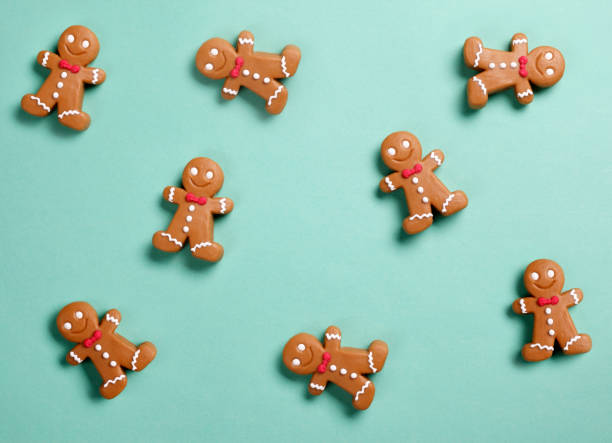 Christmas Gingerbread Man Background Gingerbread man cookies on green background. christmas paper photos stock pictures, royalty-free photos & images