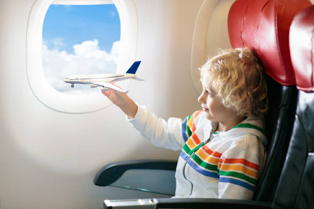 istock Child flying in airplane. Flight with kids. 1068861070