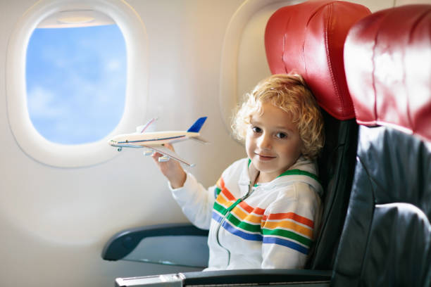 istock Child flying in airplane. Flight with kids. 1068861490