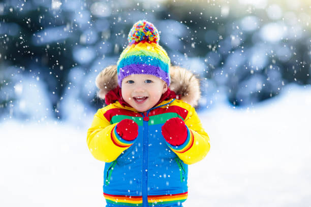 child playing with snow in winter. kids outdoors. - snow gear imagens e fotografias de stock