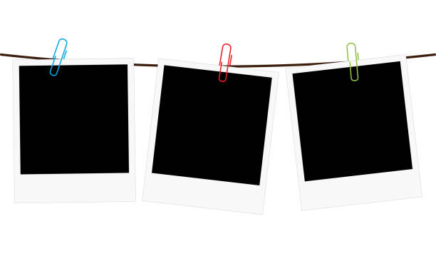 Three blank polaroid frames hanging on a rope Vector illustration of three empty blank photo polaroid frame slides hanging on a rope with colorful paperclips over white background hanging photos stock illustrations