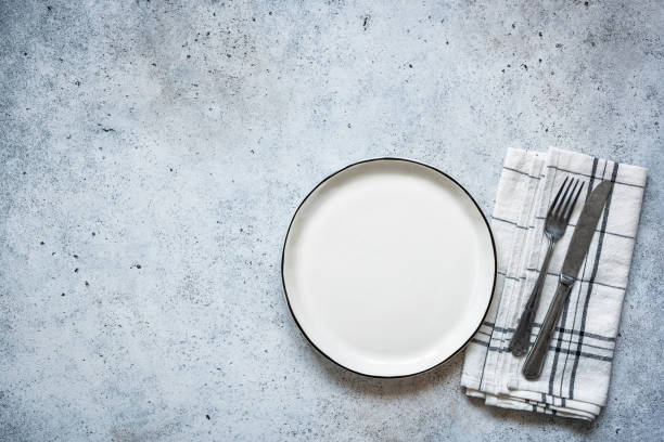 Table setting empty plate and cutlery Table setting empty plate and cutlery on concrete background. Table top view. Top view white restaurant dishes stock pictures, royalty-free photos & images