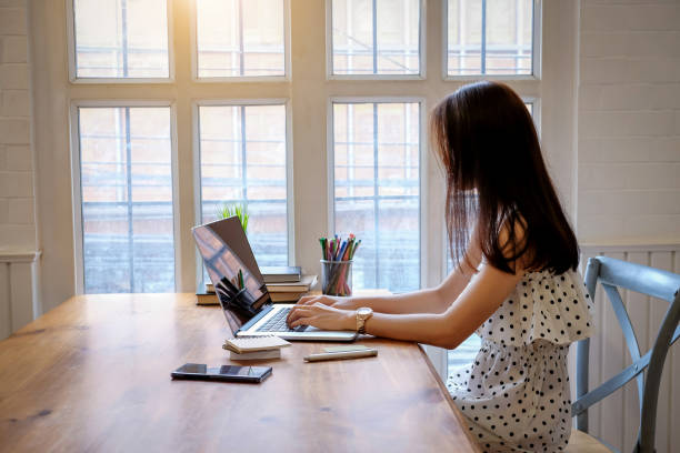 istock Beautiful Young woman working on laptop and computer at home 1068876656