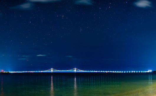 Michigan's mighty Mackinac Bridge under a star filled night sky.  Shot from Mackinac island, a long exposure shot captures the stars and the lights on the bridge.