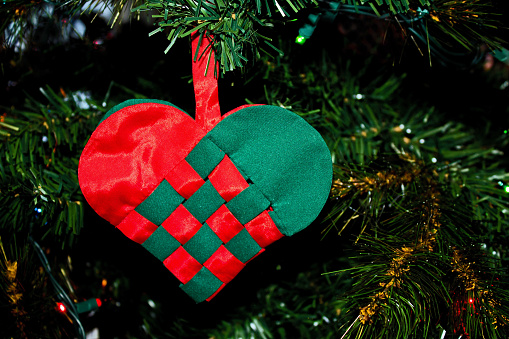 Handmade Woven Red and Green Heart Ornament Hanging on the Christmas Tree