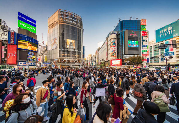 Crowded Shibuya Crossing Tokyo Japan People crossing the crowded famous Shibuya Crossing in Downtown Tokyo, illuminated Shibuya Buildings with billboards in the background. Twilight light, close to sunset. Shibuya Crossing, Shibuya Ward, Tokyo, Japan, Asia. tokyo crowds on the famous shibuya crossing japan stock pictures, royalty-free photos & images