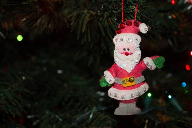 istock Handmade Fabric Santa Ornament hanging on the Christmas Tree 1068894342