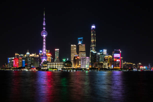 Shanghai Pudong skyline in evening light Photograph of Shanghai city skyline, Pudong side of river, on Huangpu River at night with beautiful modern skyscrapers and colorful lights shanghai tower stock pictures, royalty-free photos & images