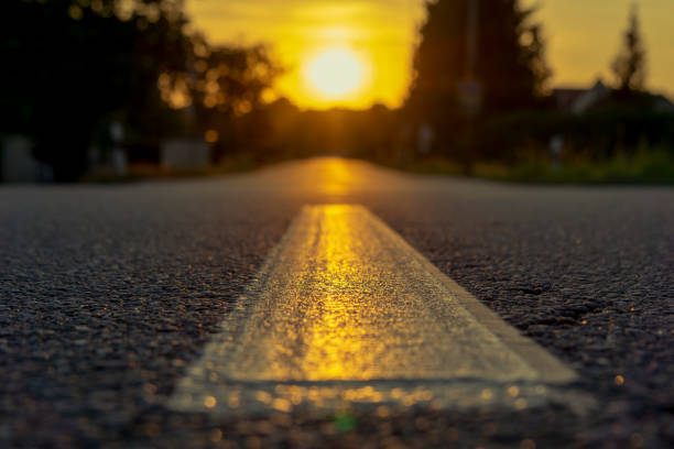 istock Close-up of a road, sun setting on the horizon 1068896554