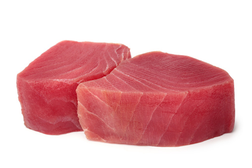 Slices of raw tuna fish meat on white background