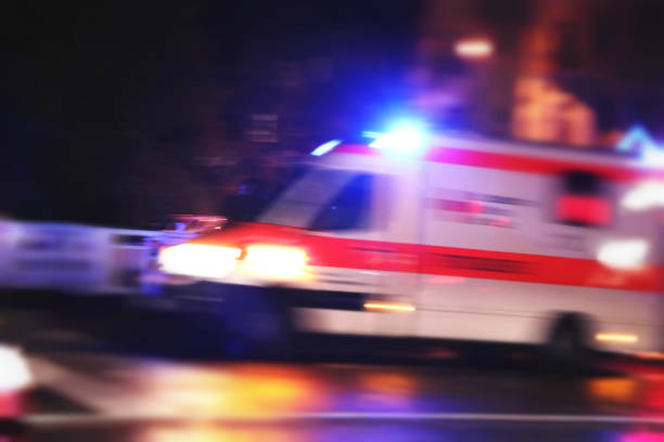 Blurry emergency car in german city. Abstract high key blurred of emergency car driving fast throught german city. Night image. ambulance photos stock pictures, royalty-free photos & images