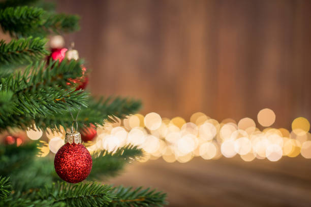 istock Fir Tree decorated with red christmas balls on rustic wood and sparkles light backgorund 1068901502