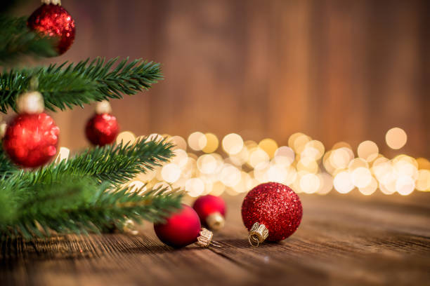Fir Tree decorated with red christmas balls on rustic wood and sparkles light backgorund stock photo