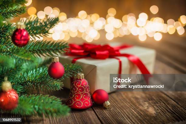 Red Christmas Ornaments And Gift On Wood Background With Defocused Lights Sparkles Stock Photo - Download Image Now