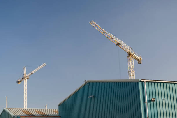 istock Twin tower crane white in empty blank blue sky at construction building site 1068909894