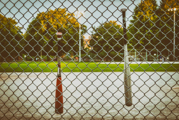 istock Baseball bats hanging on back catch fence, empty baseball diamond in background, Vintage effect. concept, copy space, background 1068910196