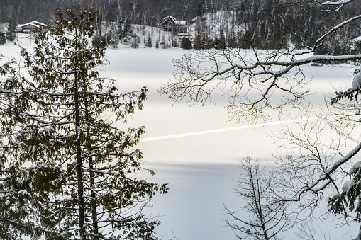 Beautiful winter scene, landscape, background, with snow covered lake which has trail across.