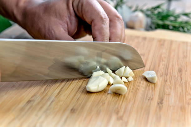 istock Chopping garlic with knife on cutting board 1068911342