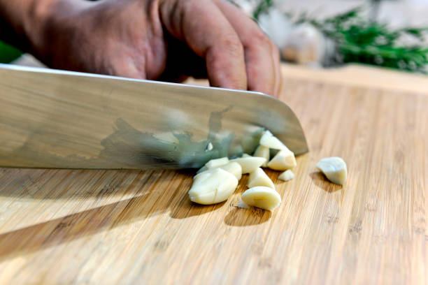 istock Chopping garlic with knife on cutting board 1068911452