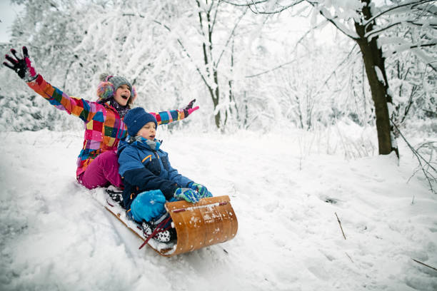 istock Brother and sister  sledding in winter. 1068935206