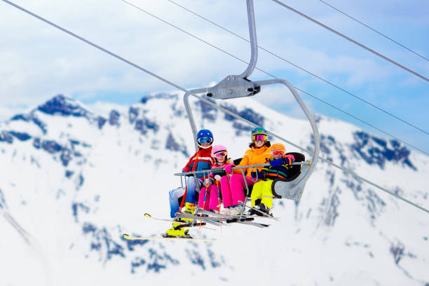 Family in ski lift in mountains. Skiing with kids Family in ski lift in Swiss Alps mountains. Skiing with young kids. Father, mother and children sitting in ski lift during Christmas vacation. Winter outdoor sports for active family. alpine skiing stock pictures, royalty-free photos & images