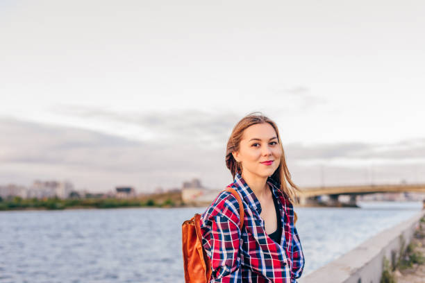 istock Smiling woman sitting on the riverbank 1068943926