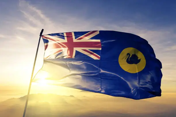 Photo of Western Australia state of Australia flag textile cloth fabric waving on the top sunrise mist fog