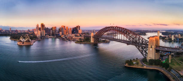 D Kirrib CBD Pink Rise High pan Colourful sky over Sydney city CBD high-rise towers at sunrise around Sydney harbour and the Sydney Harbour bridge in elevated aerial panorama. new south wales photos stock pictures, royalty-free photos & images