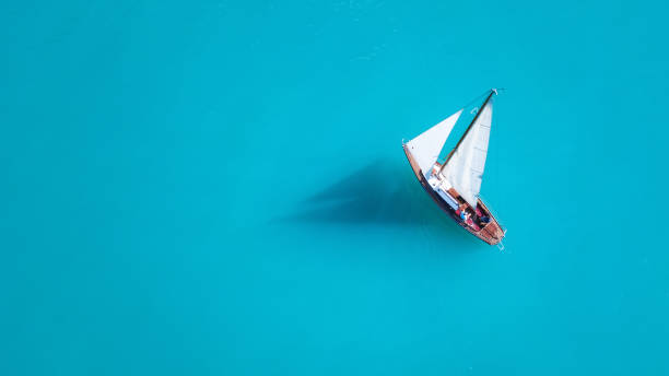 istock Yacht on the water surface from top view. Turquoise water background from top view. Summer seascape from air. Travel concept and idea 1068955204