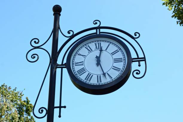 istock big round clock on a black pillar against a blue sky 1068956966