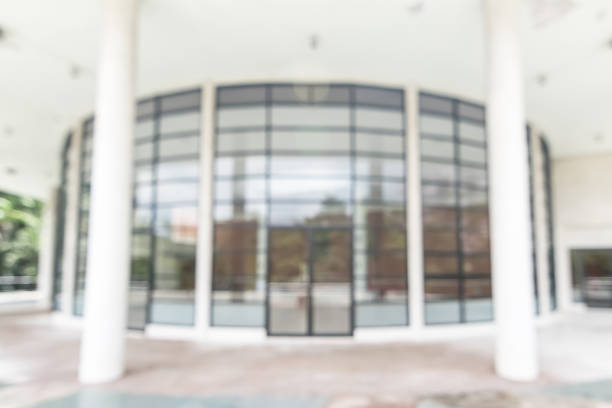istock Office or university building blur background exterior view with blurry empty lobby space, entrance hall glass wall window and light bokeh 1068972238