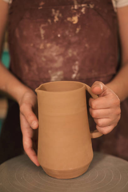 istock Pottery artist making a shape from clay 1068980240