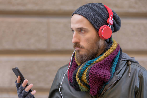 istock Young man with beard listening music 1068981090