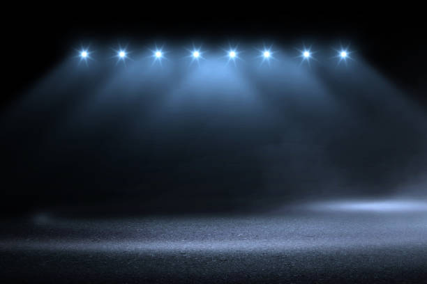 istock blue spotlight smoke studio entertainment background. 1068992760
