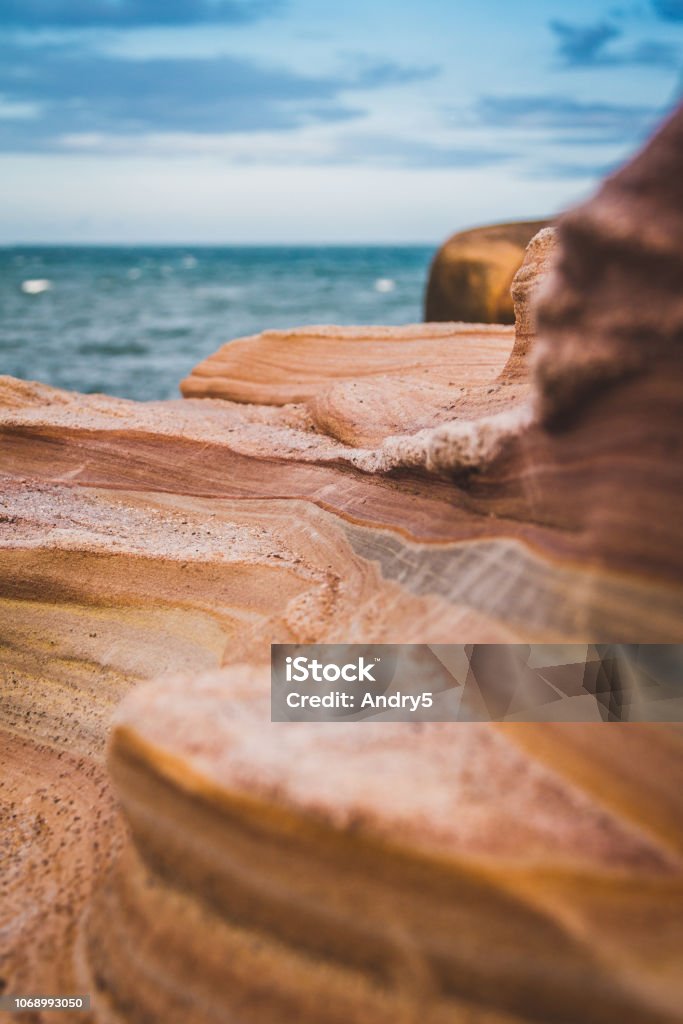Granite texture and blue sky for background Close up detail of the natural granite structure of the rock sandstone pattern in reddish colors and in distance captured blue cloudy sky and sea. The Wave - Coyote Buttes Stock Photo