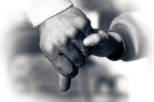 istock Father and Son Hands Holding Each Other Love and Care 1068993220