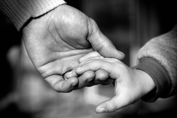 istock Father and Son Hands Holding Each Other Love and Care 1068993248