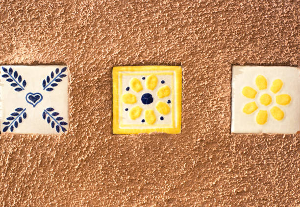 Blue and Yellow Geometric Mexican Tiles on Brown Adobe Wall with copy space.