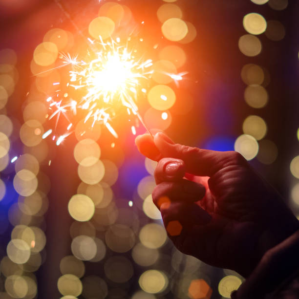 istock Person celebrating at night by holding sparkler 1069004940