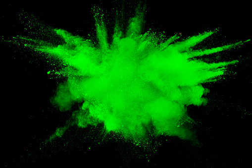 Green color powder explosion cloud  on black background.Green dust splash on dark background.
