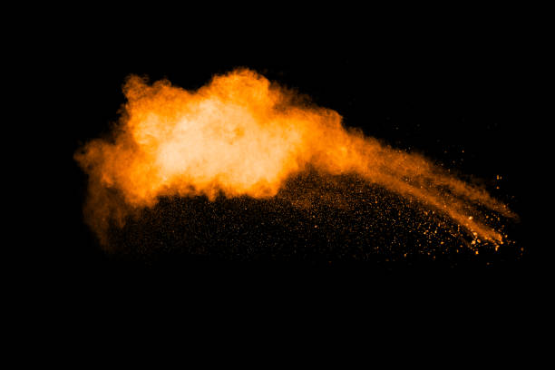 istock orange dust particles explosion on black background. Color powder dust splash. 1069011092