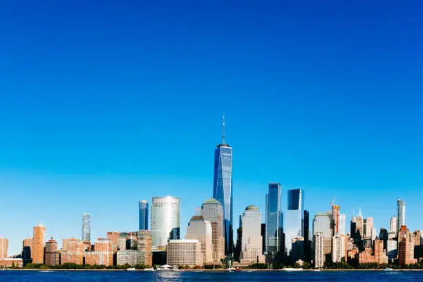 Photo of Skyline of downtown Manhattan over Hudson River under blue sky, at sunset, in New York City, USA